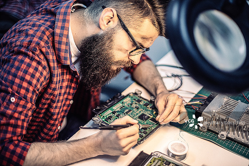 年轻的汽车修理工进行汽车芯片调校图片素材