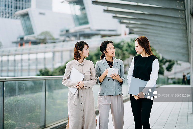 女商人手持文件平板电脑在户外讨论图片素材