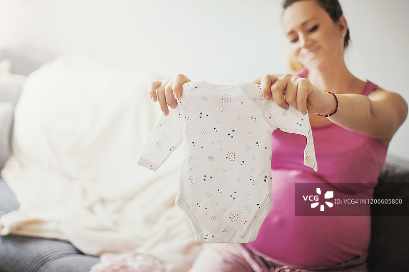 孕妇为宝宝准备衣服图片素材