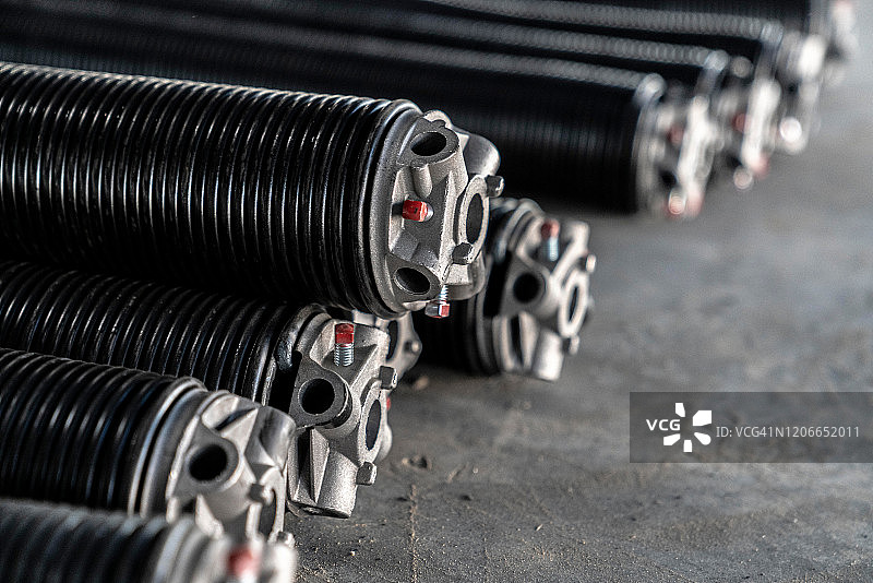 堆放在水泥地面上的商用车库门弹簧图片素材