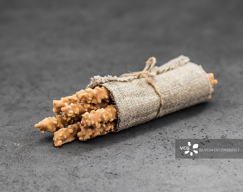 乡村风格灰色背景下的焦糖花生麦秆饼干图片素材