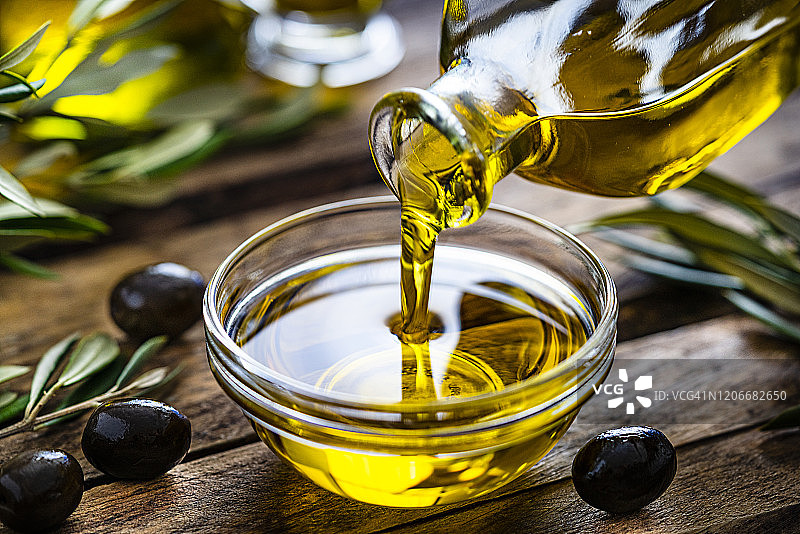 将特级初榨橄榄油倒入玻璃碗中图片素材
