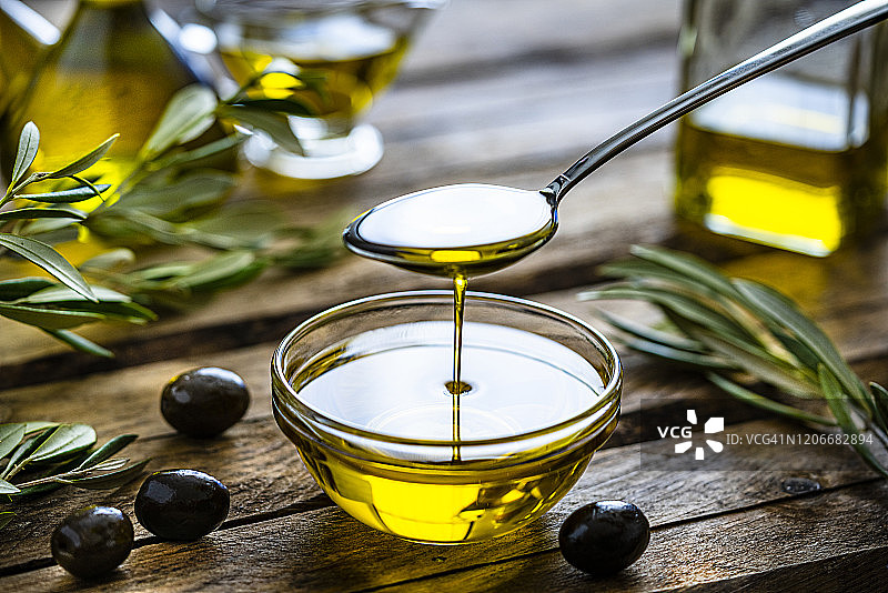 将特级初榨橄榄油倒入玻璃碗中图片素材