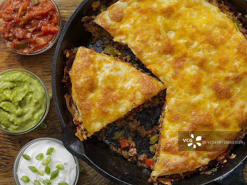 铸铁煎锅烤牛肉塔可派配酸奶油、萨尔萨酱和鳄梨酱图片素材