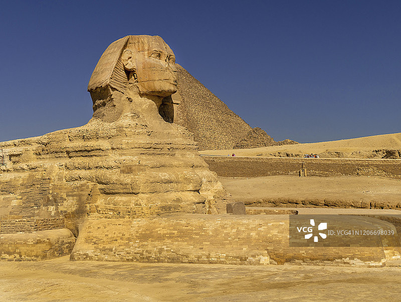 吉萨狮身人面像头部和面部的侧视图，背景是金字塔图片素材