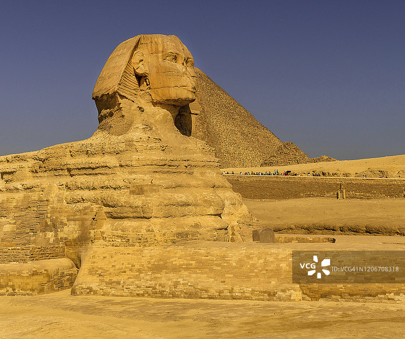 吉萨狮身人面像头部和面部的侧视图，背景是金字塔图片素材