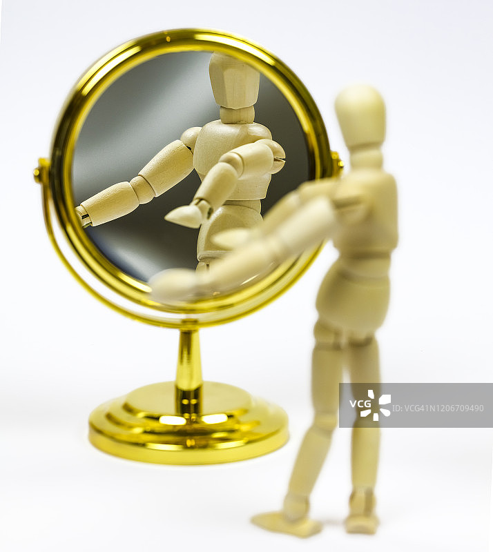 化妆镜中反射的木制人体模型图片素材