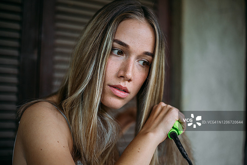 熨头发的有雀斑的漂亮女人图片素材