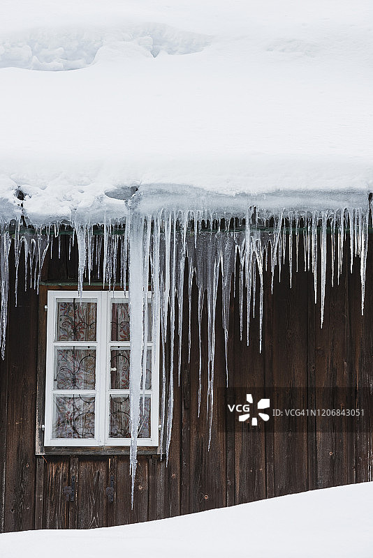 寒冷笼罩的房屋，排水沟悬挂着冰柱图片素材