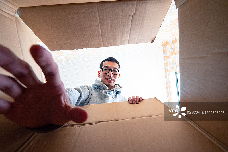 快乐的男人打开一个网购盒子图片素材