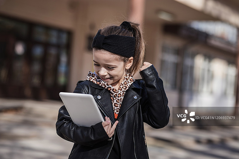 使用平板电脑的兴奋的年轻儿童图片素材