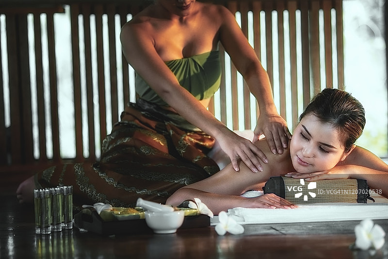 年轻漂亮女人在水疗沙龙享受按摩图片素材