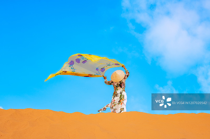 越南女人穿奥黛在美奈红沙丘图片素材