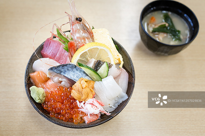 日式料理小樽海鲜盖饭 - 海胆、鲜活扇贝、鲑鱼和虾仁饭图片素材