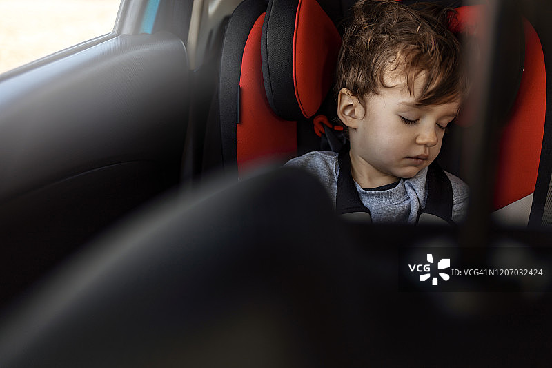 疲惫的男婴睡在汽车座椅上图片素材