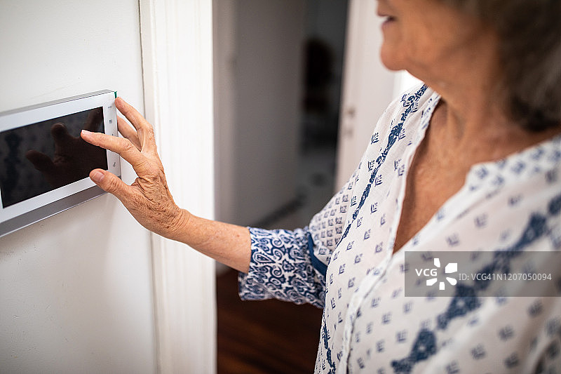 年长的女人设置防盗警报器图片素材