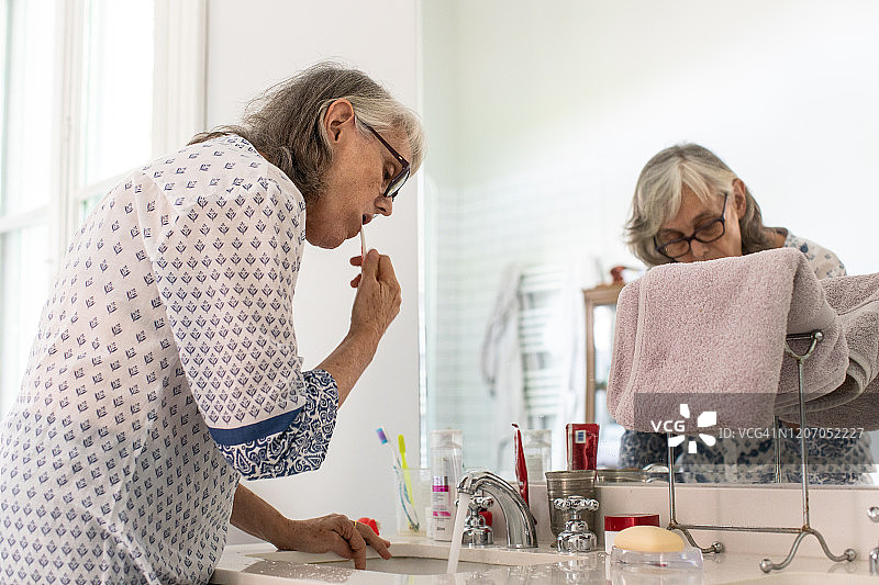 年长女性在浴室刷牙图片素材