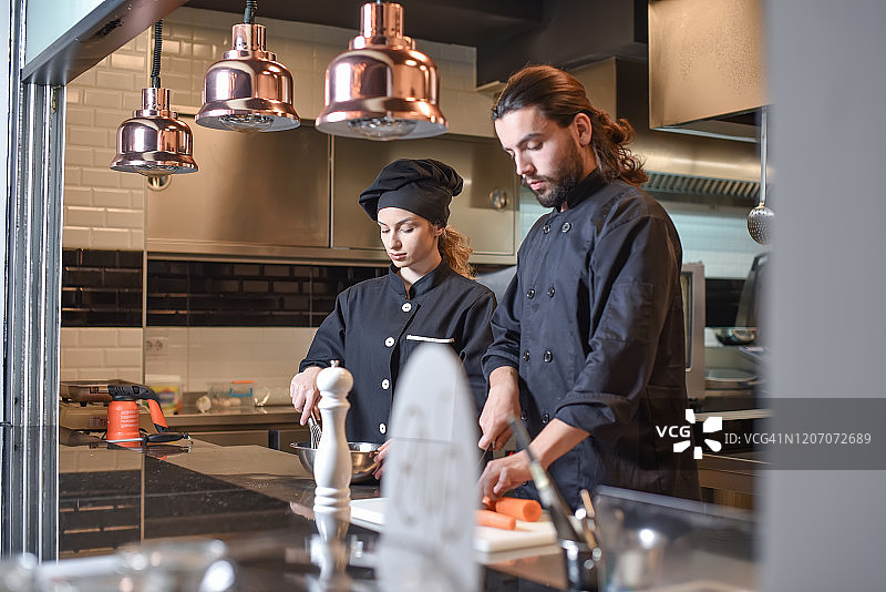 两位厨房工人在大型现代厨房准备食物图片素材
