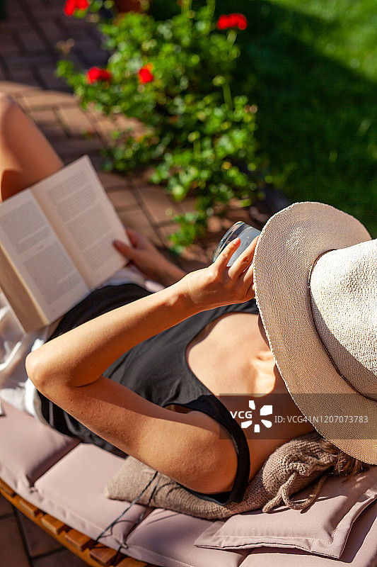 年轻女人在后院喝酒看书图片素材