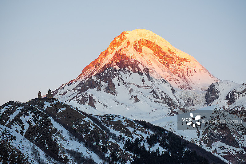 第一缕阳光下的格尔盖蒂圣三一教堂，背景是卡兹别克山，斯捷潘茨明达，卡兹别吉，格鲁吉亚图片素材