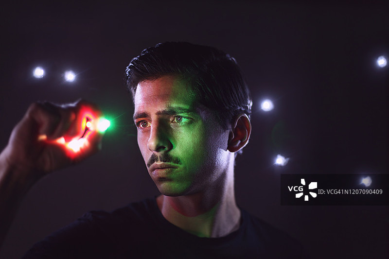 男人在黑暗背景下手持光芒图片素材