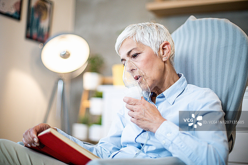 正在做吸入并阅读书籍的年长女性图片素材