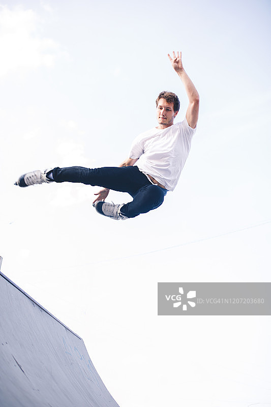 男子玩轮滑，从台座上跳跃图片素材