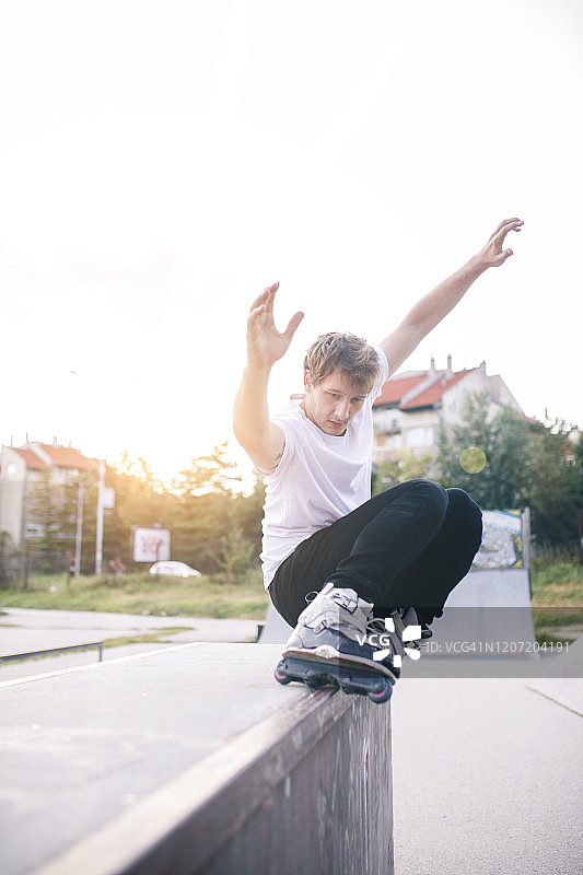 男子玩轮滑，从台座上跳跃图片素材