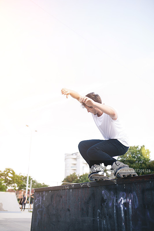 男子玩轮滑，从台座上跳跃图片素材