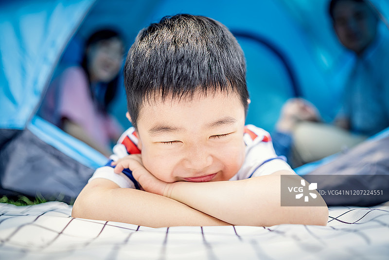 快乐可爱的男孩和父母在公园露营图片素材