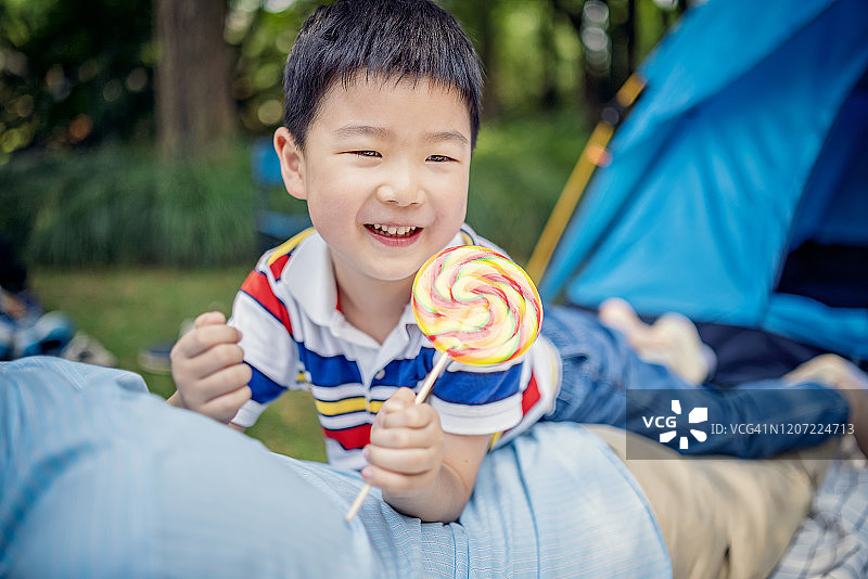 快乐的亚洲男孩享受棒棒糖图片素材