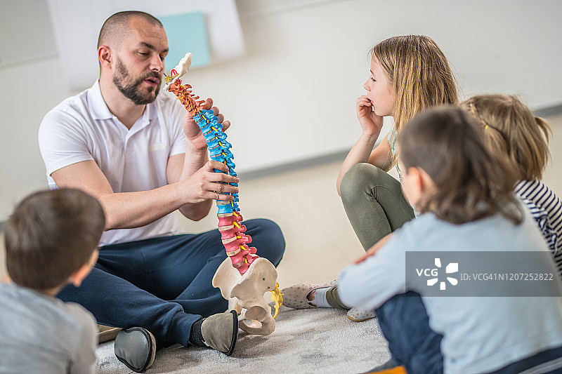 男老师向学生讲解脊柱功能图片素材