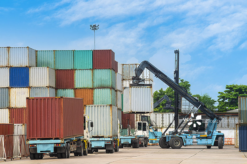 集装箱港口：起重机将集装箱装载到物流卡车上，用于出口图片素材