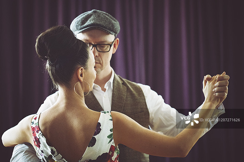 在灯光舞厅里跳舞的夫妇图片素材