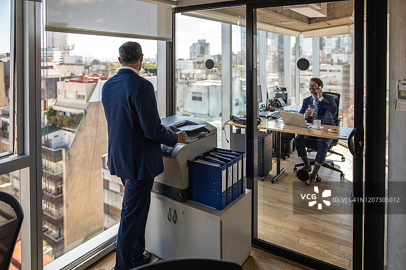 商人用办公室里的复印机复印纸质文件图片素材