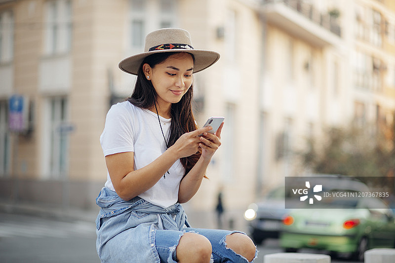 迷人的亚洲女性呼叫优步打车图片素材