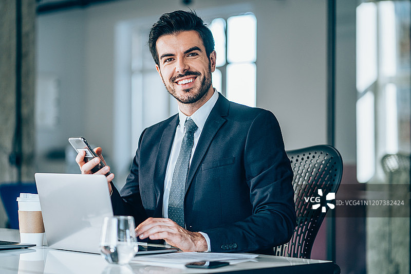 坐在现代办公室里的英俊商人图片素材
