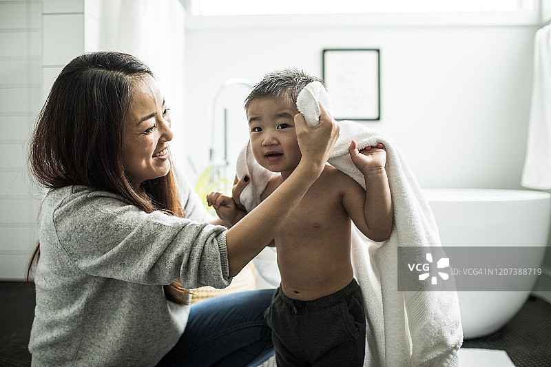 母亲在浴室里给小男孩（2岁）洗澡图片素材