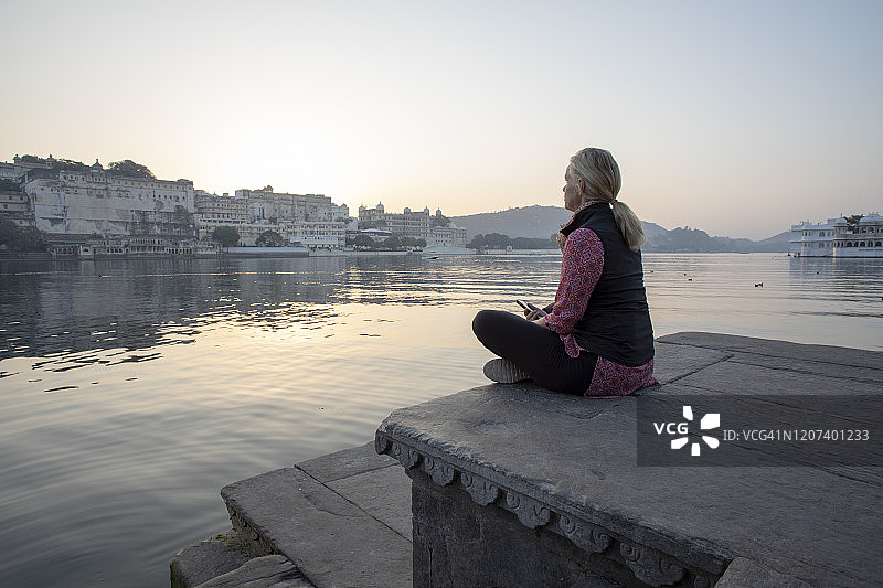 中年妇女日出时湖畔观景图片素材
