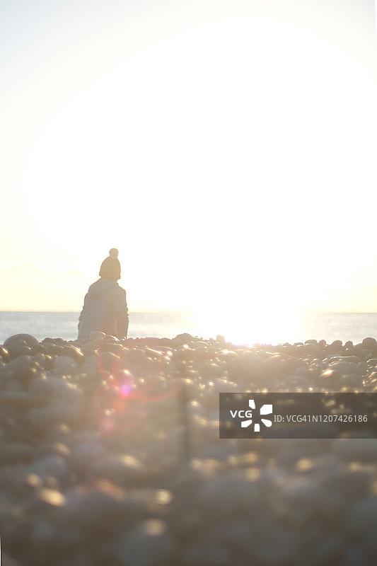 晨曦中，男孩在海边散步图片素材