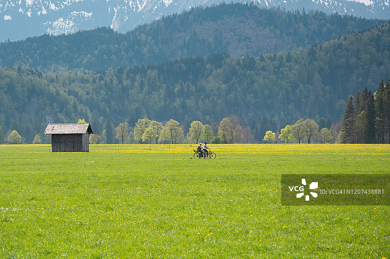 年长的男人和他的妻子在乡村风景中骑自行车图片素材