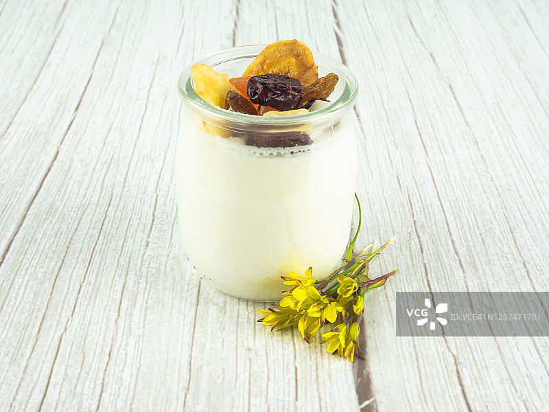 一杯含干果和黄花的酸奶图片素材