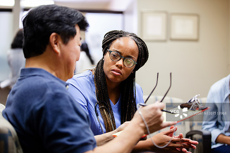 年长的病人在急诊室候诊区与护士交谈图片素材