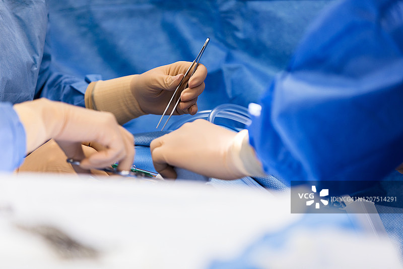 特写照片：外科医生戴着外科手套进行手术图片素材