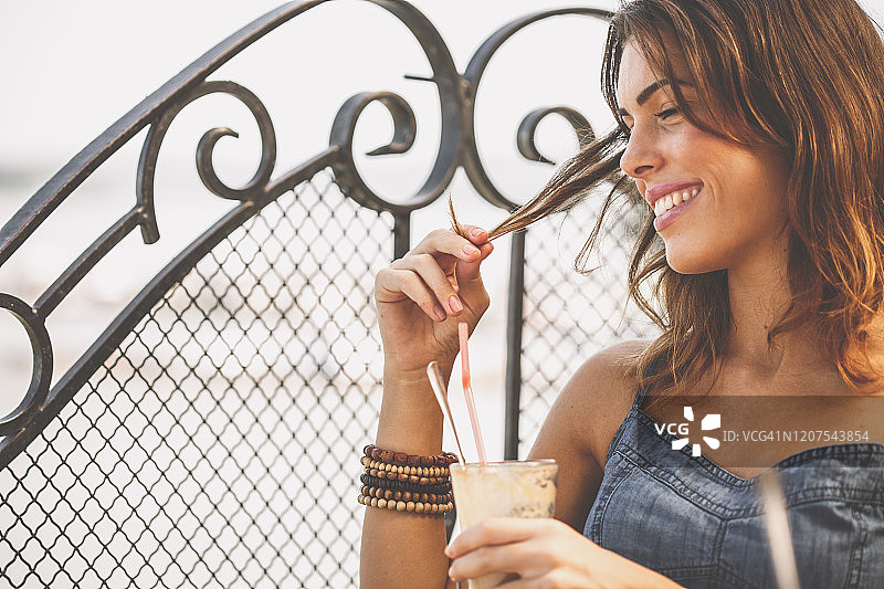 享受冰咖啡的年轻女子，略带挑逗图片素材