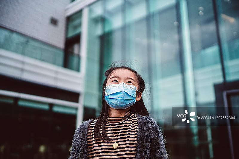 戴口罩的小女孩快乐地仰望天空图片素材