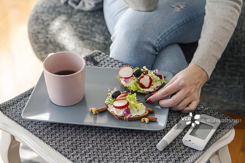 患有糖尿病的年轻女人在家吃早餐图片素材