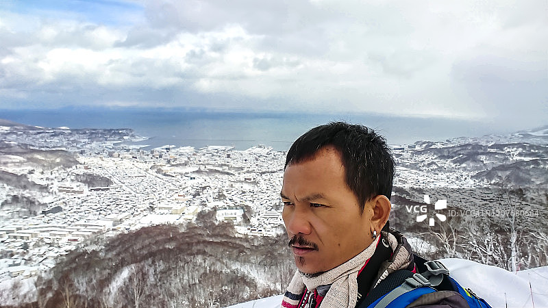 雪地里瑟瑟发抖的亚洲青年男人图片素材