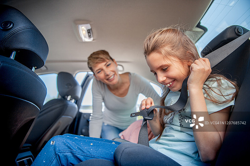 母亲教女儿如何系安全带-库存照片图片素材