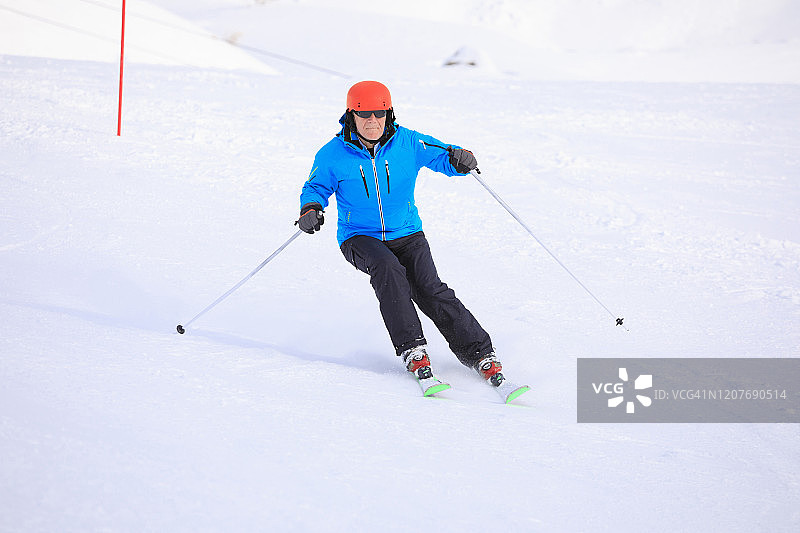 业余冬季运动：阿尔卑斯山滑雪，年长男子在滑雪胜地滑雪，高山雪景，欧洲阿尔卑斯山，意大利图片素材